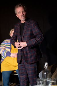 The poet Fin Hall standing up taking his turn as part of The Literal Flow Test.